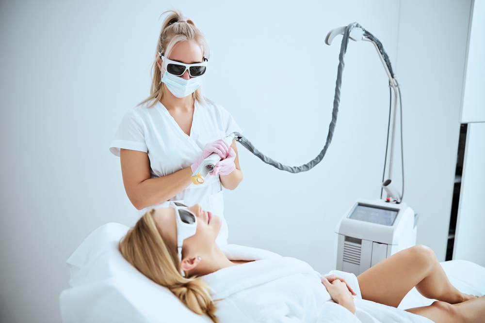 CO2 treatment | A white blonde aesthetician about to perform resurfacing laser treatment for her client.