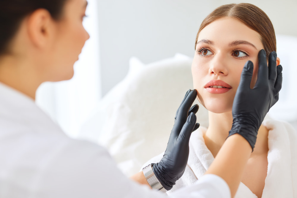 HiFu treatment | An aesthetician analysing her client's skin and face shape.