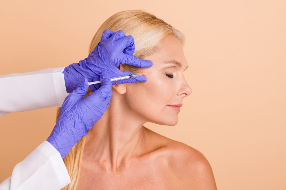 Botox | A white blonde woman receiving anti-wrinkle injections for her crow's feet.
